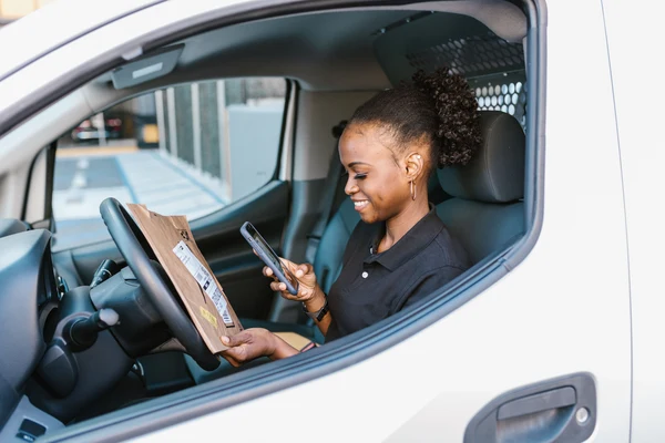 Delivery driver in van using Beem Cash Advance on phone